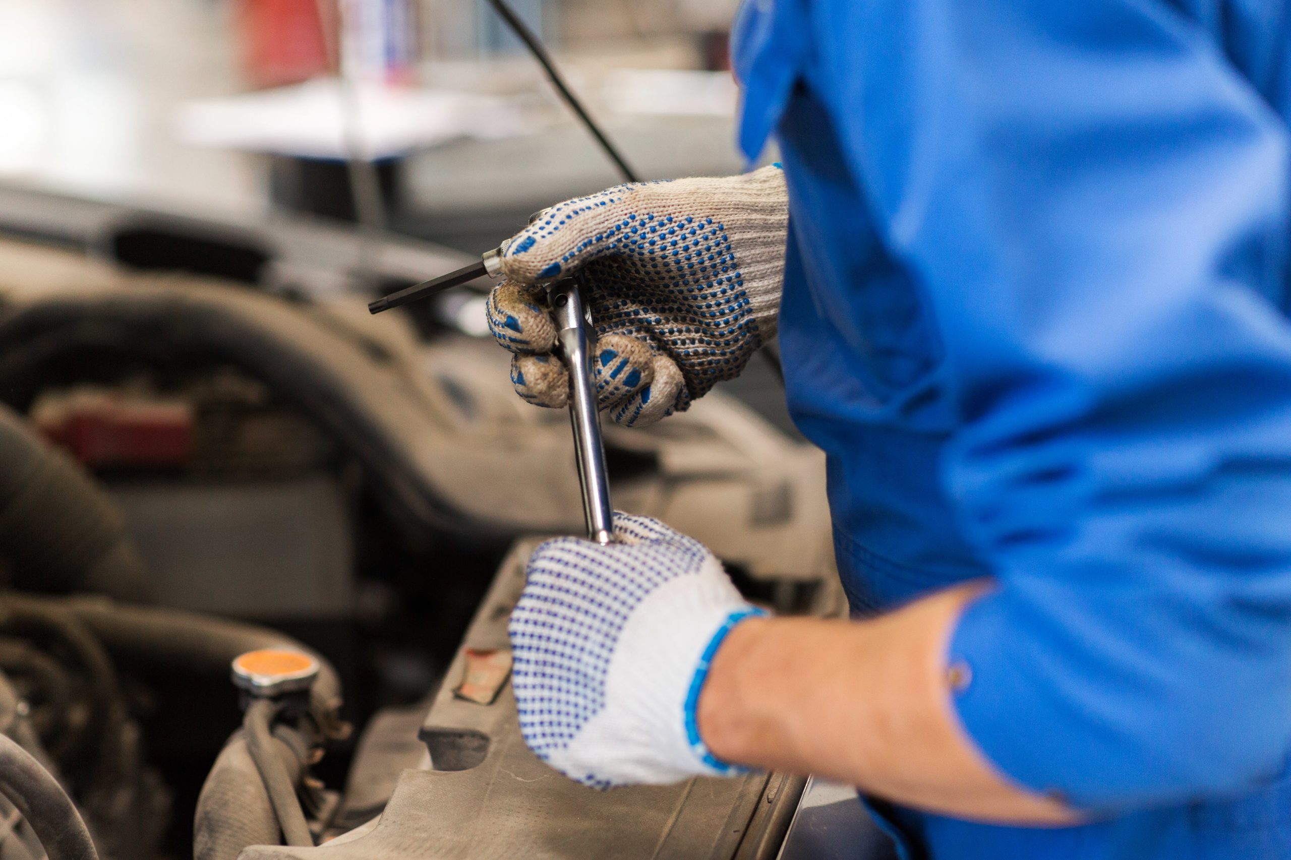 mechanic-man-with-wrench-repairing-car-at-workshop-PHG7CHR-min